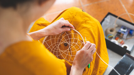 Woman making a dream catcher from threads