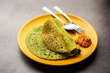 Palak dosa made using mixing spinach or keerai in batter, served with red chutney