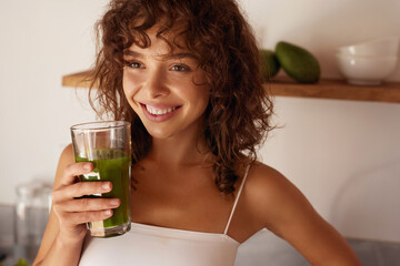 Woman Drinking Green Detox Juice, Smoothie Drink In Kitchen. Happy Smiling Girl With Glass Of...