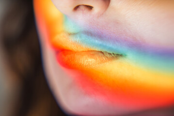 Women's lips with a rainbow. Light passes through a prism and turns into a rainbow on the lips of a young woman. lgbt symbols