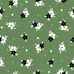 Simple vintage pattern. white and black flowers , leaves and dots. green background. Fashionable print for textiles and wallpaper.