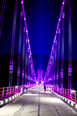 Obraz premium Colourful Dobra Chanti hanging bridge over Tehri Lake. Night view of Dobra-Chanti bridge. The 725-metre long Dobra Chanti suspension bridge over the Tehri lake. 