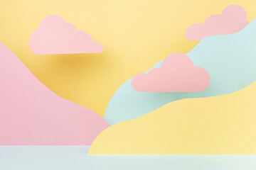 Abstract pastel colorful stage mockup - paper landscape with mountains yellow, mint color, pink clouds in cute fashion style. Template for advertising, design, presentation cosmetic produce, card.