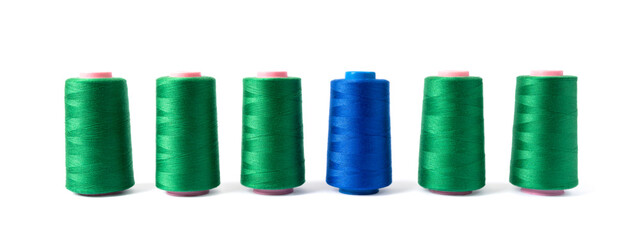 Sick spools of sewing thread in green and blue color isolated on white background. The concept of clothing production.