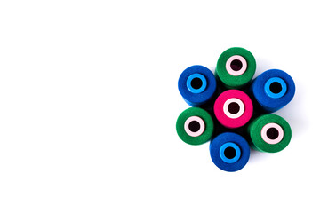 Top view of colored spools of thread stacked in a circle. Copy space