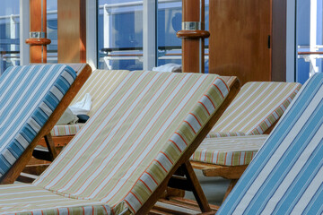 Sun loungers at indoor pool solarium of ocean liner cruiseship cruise ship with patterned cushions and skylight glass roof dome