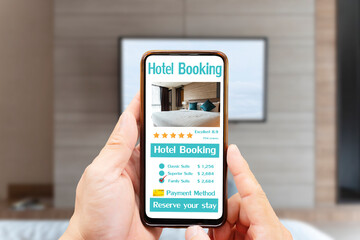 Man hand holding smartphone with hotel booking screen in home app