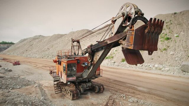 Old soviet excavator for industrial mining. Machinery for civil engineering and precious metal surface mining. Aerial view in quarry.