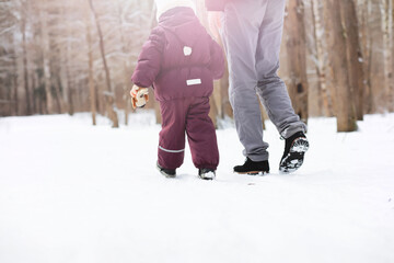 Happy family playing and laughing in winter outdoors in the snow. City park winter day.