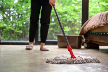 close-up image of mop girl doing housekeeping Use a mop to clean the water in your home room.