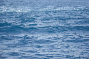 Waves of blue sea water. Abstract background, full frame. Copy space. Selective focus.