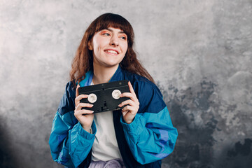 Young sporty woman 80 and 90's style. 90s fashion positive girl with cassette dvd