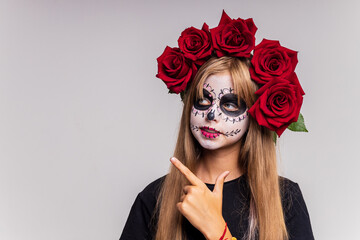 Portrait of teenager girl in a witch costume, on studio background. halloween make up