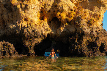 A woman in the water on a bow at Praia dos Arrifes, Algarve beach, Albufeira. Portugal