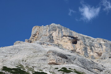 Fototapeta na wymiar Val Badia, Italy-July 18, 2022: The italian Dolomites behind the small village of Corvara in summer days with beaitiful blue sky in the background. Green nature in the middle of the rocks.
