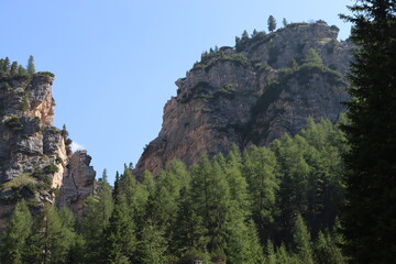Val Badia, Italy-July 18, 2022: The italian Dolomites behind the small village of Corvara in summer days with beaitiful blue sky in the background. Green nature in the middle of the rocks.