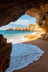 A natural summer beach cave at Praia da Coelha, Algarve, Albufeira. Portugal, vertical photo