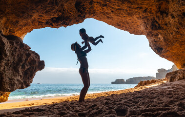 Mother with son in the cave on the beach in the Algarve, Praia da Coelha, Albufeira. Portugal