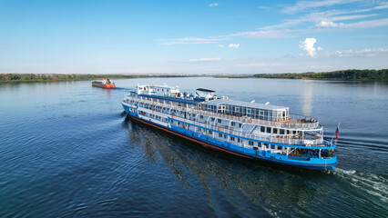 Cruises on the liner along the Volga. Passenger ship with tourists on board flying to overtake a...