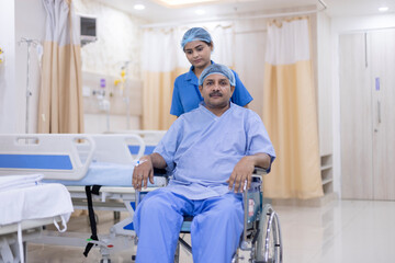 Young nurse wearing uniform assisting mature patient on wheelchair. Portrait of sick mature man undergoing medical treatment. They are at hospital ward. 
