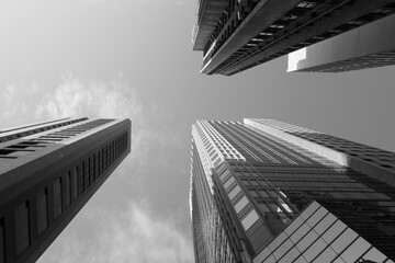 Parallel buildings.  Looking straight up at three office blocks in Hong Kong.  In black and white.
