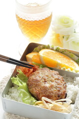 Homemade bento, minced pork and tofu patty on rice served with orange and namul 