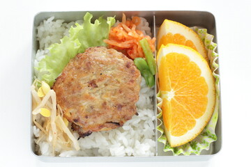 Homemade bento, minced pork and tofu patty on rice served with orange and namul 