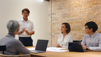 Asian leader with happy young praising for good work or thanking for good job done at briefing meeting with diverse employees and respect bonus for good work. employee reward recognition concept