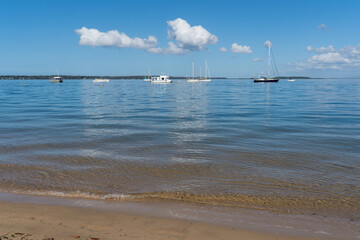 Boats moored on the clear calm waters offshore from Coochiemudlo Island, Queensland, Australia. 