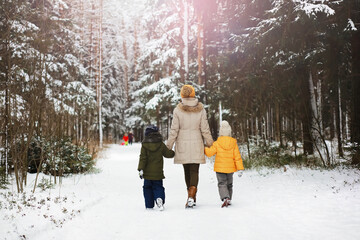 Happy family playing and laughing in winter outdoors in the snow. City park winter day.