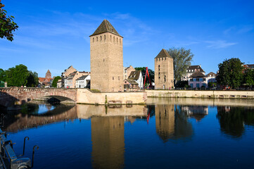 Strasbourg, France: Medieval bridge towers and bridge over the river at sunset. Ponts couvert.