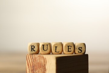 Word Rules made of cubes with letters on wooden block, space for text