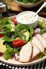 Delicious salad with chicken, arugula and avocado on plate, closeup