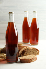 Bottle of delicious fresh kvass, spikelets and bread on white wooden table