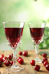 Fototapeta na wymiar Delicious cherry wine with ripe juicy berries on wooden table