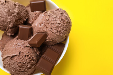 Delicious chocolate ice cream on yellow background, top view