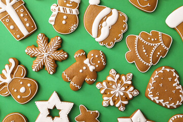 Different Christmas gingerbread cookies on green background, flat lay