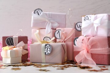 Gifts for Christmas advent calendar and confetti on white table