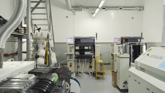 Interior of modern automated production of microcircuits and microchips. Electronic equipment production. Robot produces computer parts. Industrial factory machine producing computer motherboards.