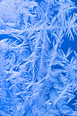 Frozen texture. Frost patterns on frozen window as a symbol of Christmas wonder.