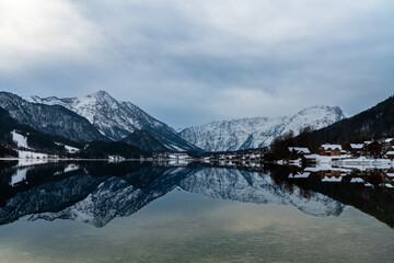 Stunning panorama view of Grundlsee lake with snow covered mountain peaks of Styrian Alps in background on a sunny winter day, Ausseerland - Salzkammergut region, Styria, Austria - 526282458