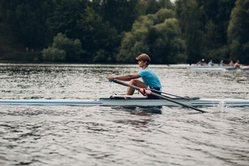 Sportsman single scull man rower rowing on boat. © primipil