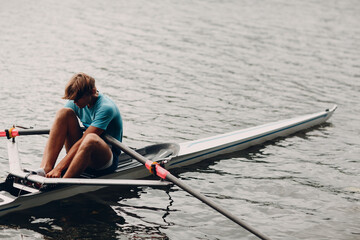 Sportsman single scull man rower rowing on boat. © primipil