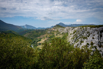 Amazing, mountain landscape of Croatian rocky hills covered in forest and vegetation with Cetina river passing through the canyon in the valley