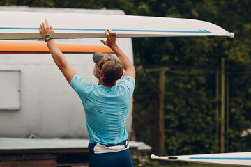 Fototapeta na wymiar Sportsman single scull man rower prepare to competition with boat.