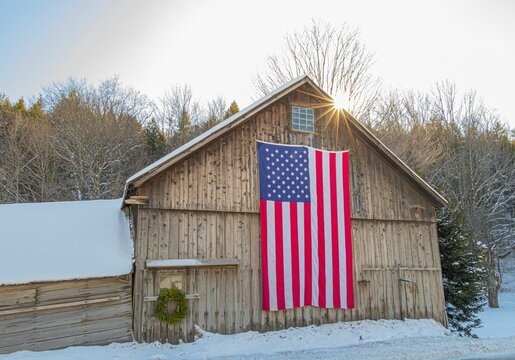 Closeup shot of a wooden house with an American flag in Vermont, USA