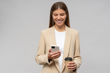Successful woman executive manager smiling using smartphone holding paper cup of coffee
