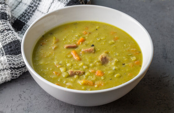 Pea and ham soup on grey counter - image