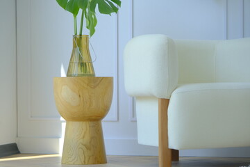 vase with flowers on the table and white armchair