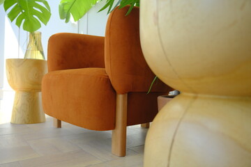 Orange armchair among houseplants in the corner of the living room